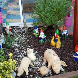 Escuela Infantil Lacaba estatuas de gnomos y cerdos